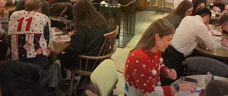Teams in Christmas jumpers working on their answers at last year's 5:05 Christmas Quiz