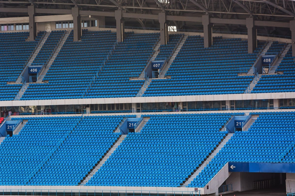 Empty light blue seats in the stands of a football stadium