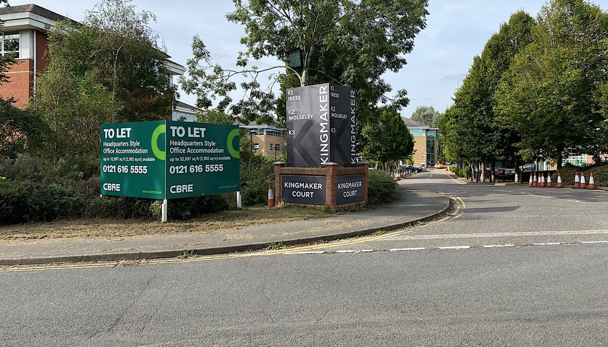 A To Let board for headquarters-style office accommodation at the entrance to a business park